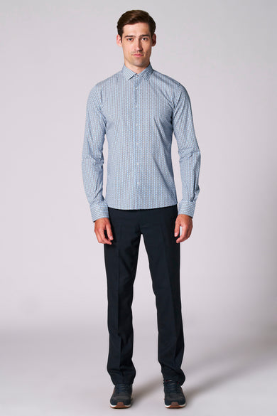 Chemise multicolore à longues manches de Bruce & Butler, avec un fin motif géométrique, portée avec un pantalon noir et des baskets.