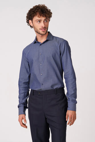 Blauw overhemd met lange mouwen van Bruce & Butler, met fijn dessin en gedragen met een donkere pantalon.
