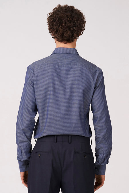 Blauw overhemd met lange mouwen van Bruce & Butler, met fijn patroon en gedragen met donkere pantalon, gezien vanaf de achterkant.
