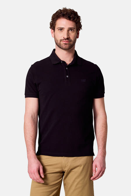 Polo noire à manches courtes de Bruce & Butler, portée avec un pantalon kaki.