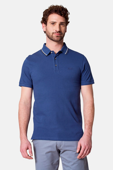 Man in blauwe polo met grijze broek.