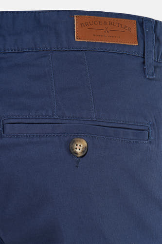 Shorts bleus de Bruce & Butler, avec un nœud brun sur la poche arrière et une étiquette en cuir.