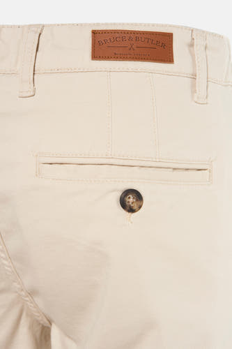 Bermuda beige de Bruce & Butler, avec une poche arrière à bouton et un étiquette en cuir.