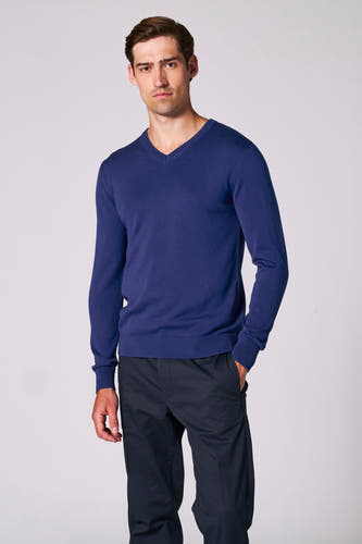 T-shirt à col V bleu de Bruce & Butler, avec des manches longues et associé à un pantalon foncé.