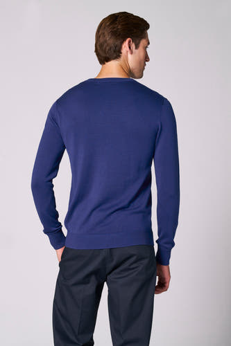 T-shirt à col V bleu de Bruce & Butler, dos visible, associé à un pantalon foncé.