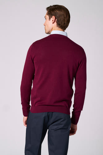 Veste de Bordeaux avec col V de Bruce & Butler, portée avec un chemisier à carreaux et un pantalon foncé.