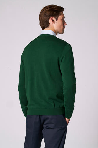T-shirt vert avec col V de Bruce & Butler, vu de dos, porté avec un chemisier imprimé en dessous et un pantalon foncé.