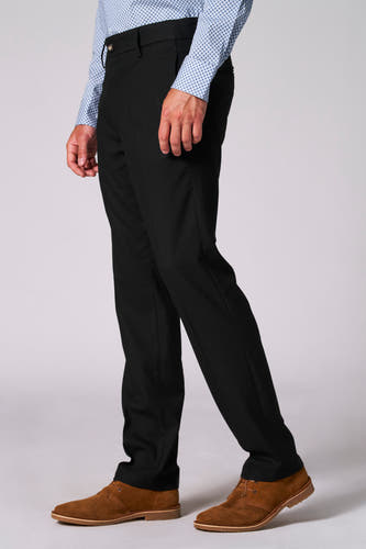 Pantalon de costume noir Bruce & Butler, avec une finition légèrement texturée, porté avec des chaussures en cuir marron et un chemisier bleu.