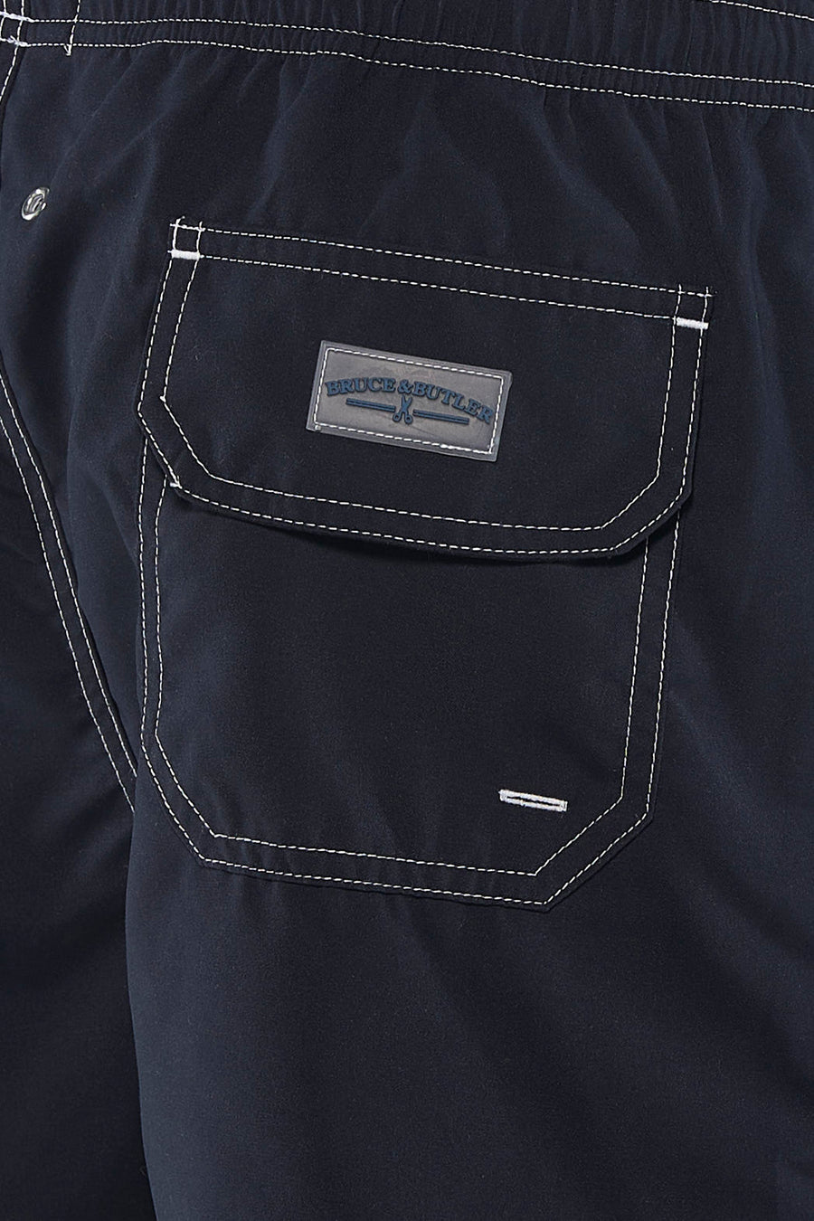 Short de bain noir Bruce & Butler avec surpiqûres à pois blancs et une poche arrière avec écusson logo ciseaux.