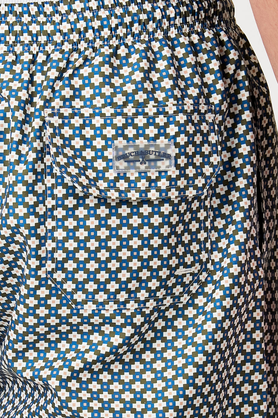 Short de bain multicolore de Bruce & Butler avec motif carré géométrique, taille élastique et étiquette de poche arrière transparente.