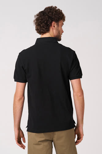 Zwarte polo met korte mouwen van Bruce & Butler, rugaanzicht, gecombineerd met een kaki broek.
