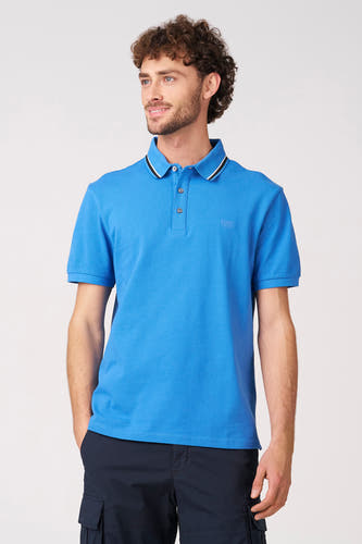 Polo bleu à manches courtes de Bruce & Butler, vue de dos avec un col rayé et un pantalon cargo foncé.