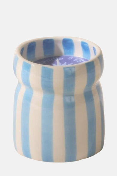 Bougie bleue de PADDY WAX, avec des stries verticales sur un support céramique.
