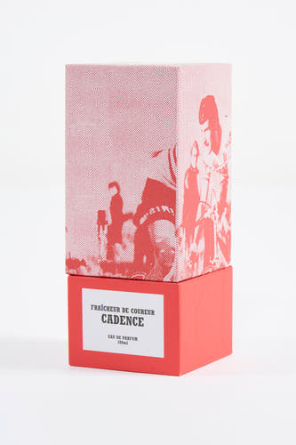 Parfum rouge du Cyclo Club Marcel avec un motif de cyclistes sur la boîte supérieure.