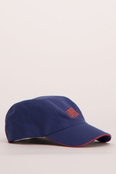 Casquette bleue du Cyclo Club Marcel avec des détails rouges le long du bord de la visière.