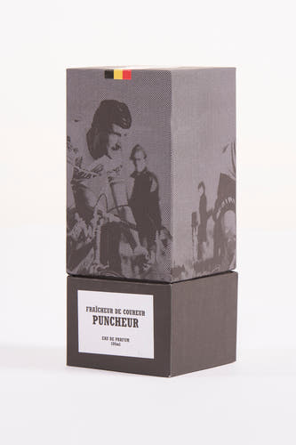 Parfum noir de Cyclo Club Marcel, avec un motif à carreaux et un drapeau belge sur le dessus de la boîte.