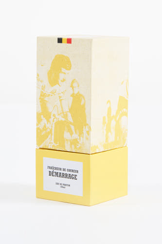 Parfum jaune du Cyclo Club Marcel, avec une image d'un cycliste et le drapeau belge sur la boîte.
