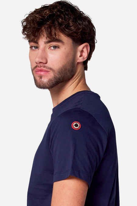 T-shirt bleu à manches courtes de Cyclo Club Marcel, avec col rond et logo sur la manche.