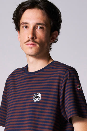 T-shirt multicolore à manches courtes de Cyclo Club Marcel, avec des rayures horizontales et un blason sur la poitrine.