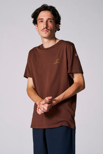 T-shirt marron à manches courtes du Cyclo Club Marcel, avec une impression jaune sur la poitrine et un logo sur la manche.