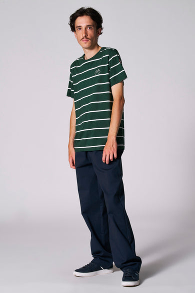 T-shirt rayé vert avec manches courtes de Cyclo Club Marcel, porté avec un pantalon bleu marine et des baskets.