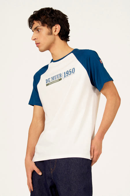 Wit T-shirt met korte blauwe mouwen van Cyclo Club Marcel, met opschrift en gedragen met een donkere jeans.
