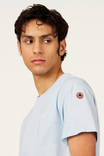 T-shirt bleu à manches courtes de Cyclo Club Marcel, avec un badge rond sur la manche.