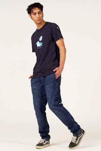 T-shirt bleu à manches courtes de Cyclo Club Marcel, avec un imprimé et combiné avec un jean et des baskets vertes.