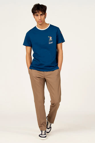 T-shirt bleu à manches courtes de Cyclo Club Marcel, avec un imprimé sur la poitrine et combiné avec un pantalon marron et des baskets.