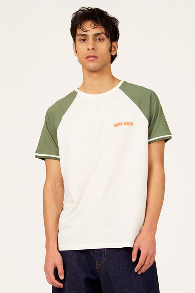 T-shirt blanc à manches courtes Cyclo Club Marcel, avec manches raglan vert olive contrastantes et un jean.