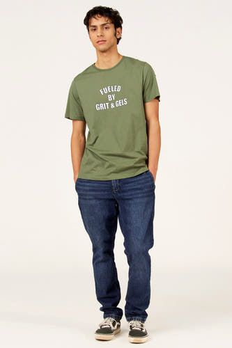T-shirt vert à manches courtes de Cyclo Club Marcel, avec imprimé texte et porté avec un jean et des baskets.