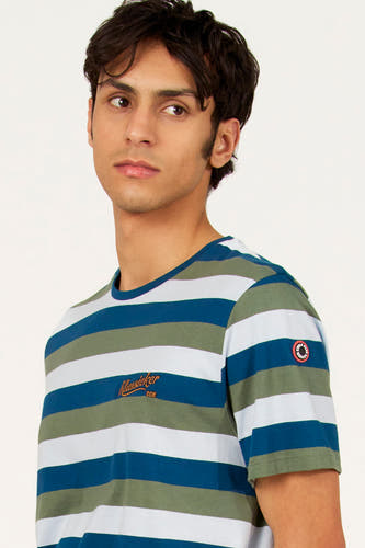 T-shirt multicolore à manches courtes de Cyclo Club Marcel, avec des rayures horizontales et un écusson rond sur la manche.