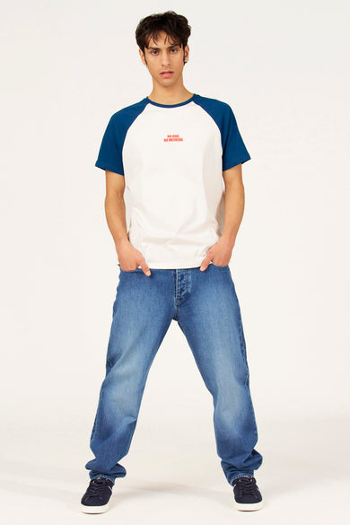 T-shirt blanc à manches courtes Cyclo Club Marcel, avec manches raglan bleues, porté avec un jean et des baskets.