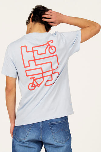 Blauw T-shirt met korte mouwen van Cyclo Club Marcel, met rode fiets print op de rug, gecombineerd met jeans.
