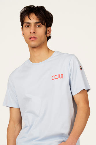 T-shirt bleu à manches courtes de Cyclo Club Marcel, avec un logo rouge sur la poitrine et un écusson sur la manche.
