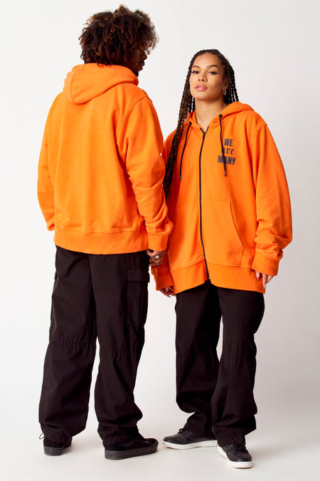 Pantalon cargo noir de COELY, porté avec un pull orange et des baskets noires.