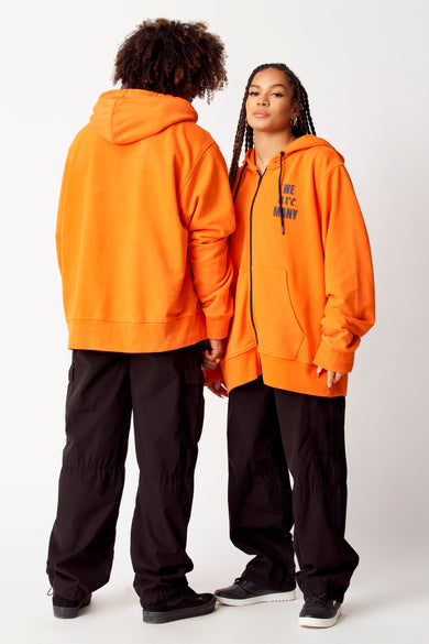 Hoodie orange de COELY, dos, avec capuchon et pantalon noir.