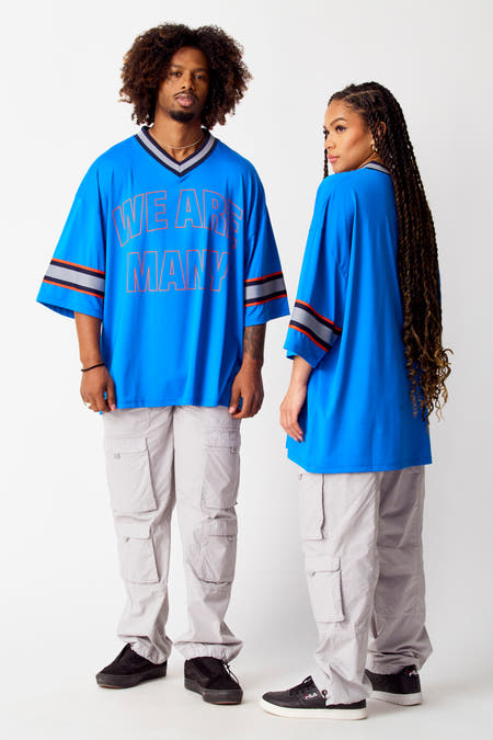 T-shirt bleu de COELY, avec des détails rayés sur les manches et un étiquette dans le col.