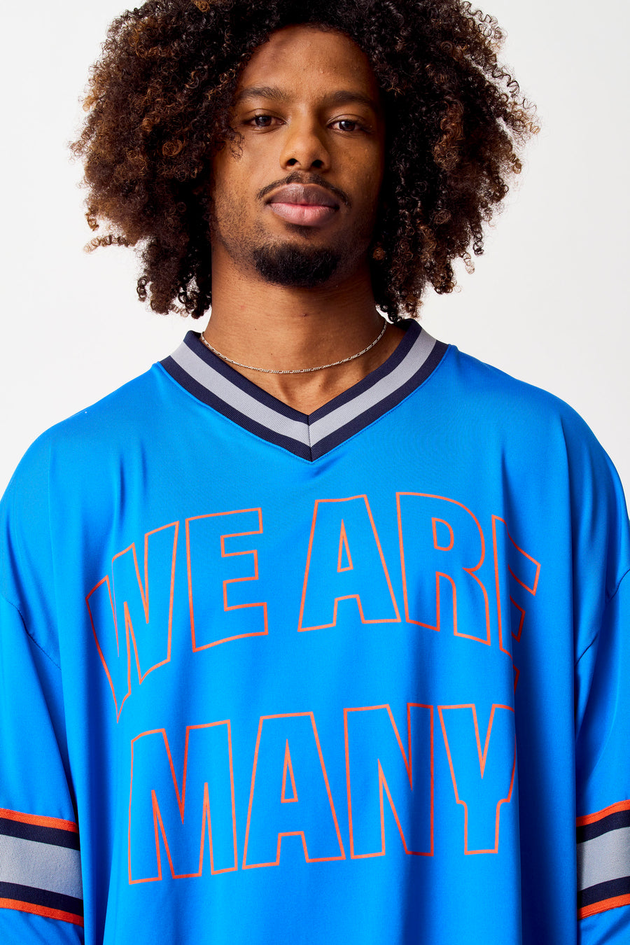 T-shirt bleu de COELY, avec des lettres oranges et un col V bleu marine et gris.