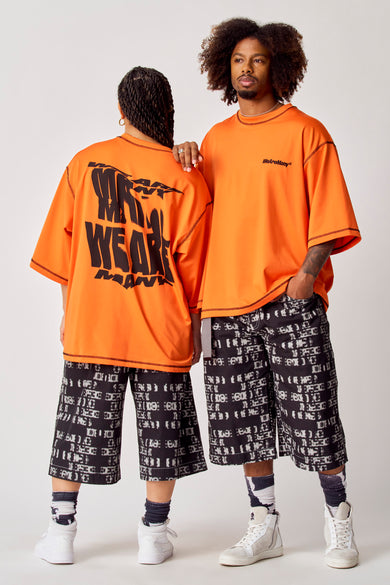 T-shirt orange à manches courtes de Coely, avec une grande impression de texte noir sur le dos.
