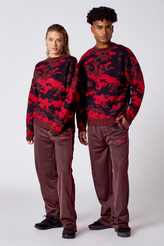 T-shirt rouge avec col rond de COELY, à motif camouflage en tons de rouge, marron et noir.