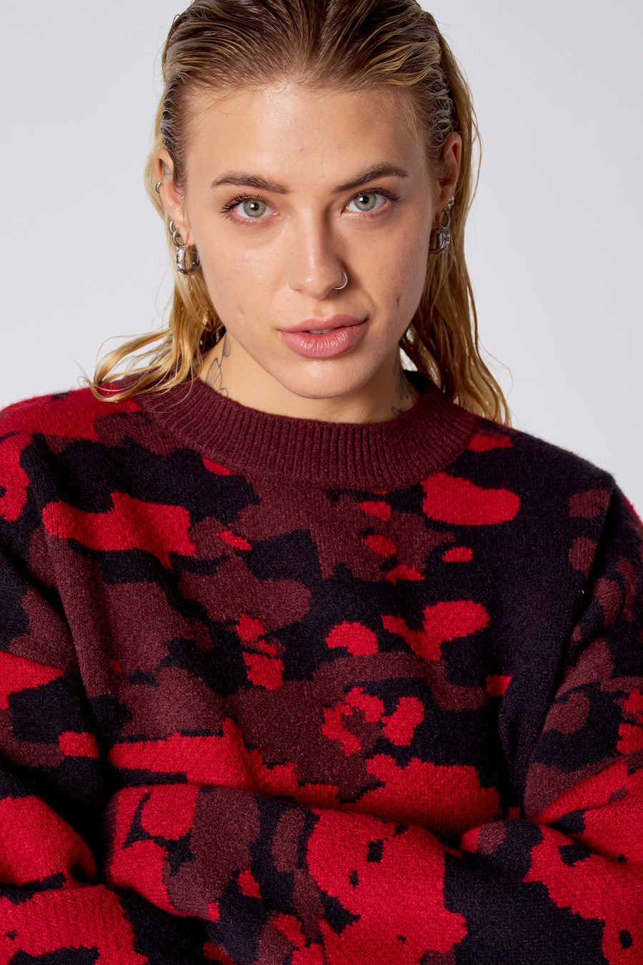 T-shirt rouge avec col rond de COELY, doté d'un motif camouflage distinctif en rouge et noir.