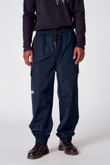 Pantalon de travail vert de COELY, avec une ceinture élastique, des poches et des fermetures à glissière aux chevilles, vu de derrière.