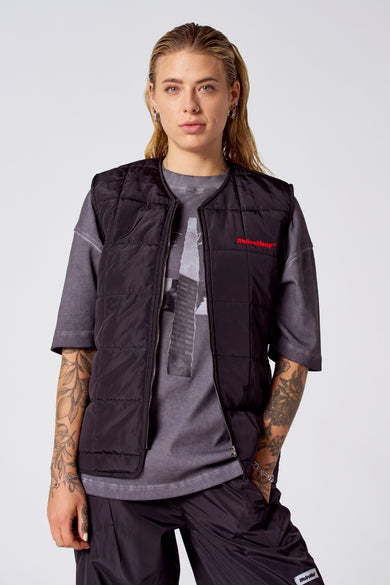 Gilet COELY de COELY, fer ferche et et et détailsés, porté sur un T-shirt gris et une pantalon noir.
