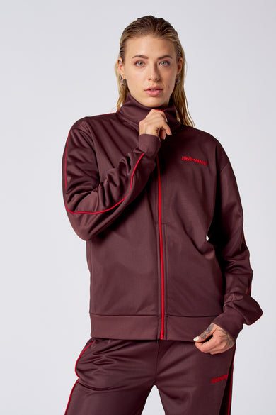 Maillot d'entraînement de Bordeaux de Coely, avec des fermetures éclair rouges et le mot "WeAreMany" brodé, porté avec un short d'entraînement correspondant.