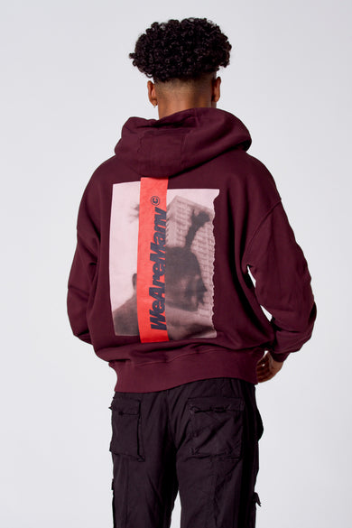 Gilet de couleur bordeaux de COELY, avec une impression graphique sur le dos et porté avec des pantalons cargo foncés.