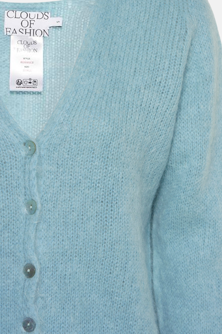 Gilet en maille bleu clair de Clouds of Fashion avec une texture duveteuse, des boutons et une étiquette de marque visible.