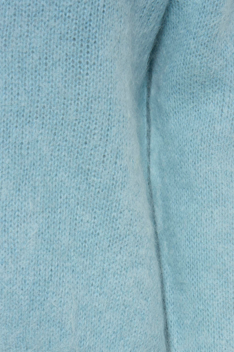 Gilet bleu clair de Clouds of Fashion, gros plan sur la matière tricotée et duveteuse avec pli vertical.