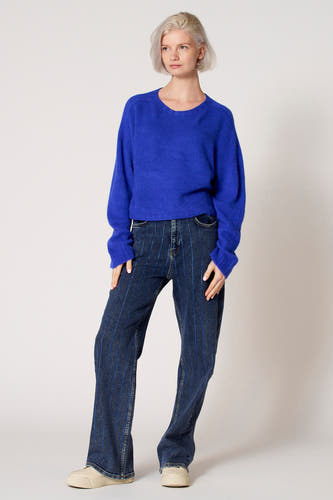T-shirt bleu avec col rond de Clouds of Fashion, à longues manches et associé à des jeans rayés.