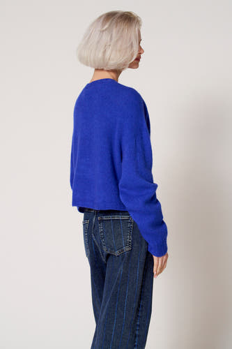 T-shirt bleu avec col rond de Clouds of Fashion, associé à des jeans bleus marine à rayures verticales.